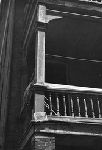 Sagging porch column and patched railing.