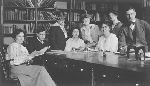 Eight students gathered around a table in the library.