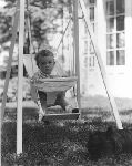 Charles A. Lindbergh Jr. in a swing, with Skean, the Lindbergh's Scotch terrier, 1931.